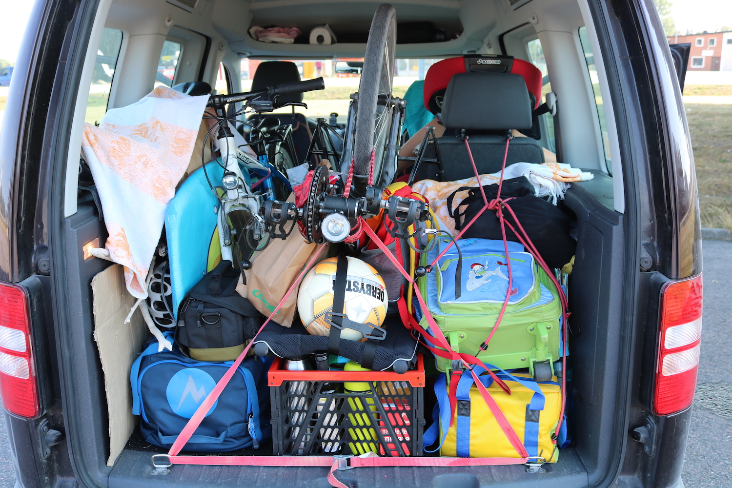 Suchbild: im Auto befinden sich ein Mountain Bike, ein Pino und zwei Kinder