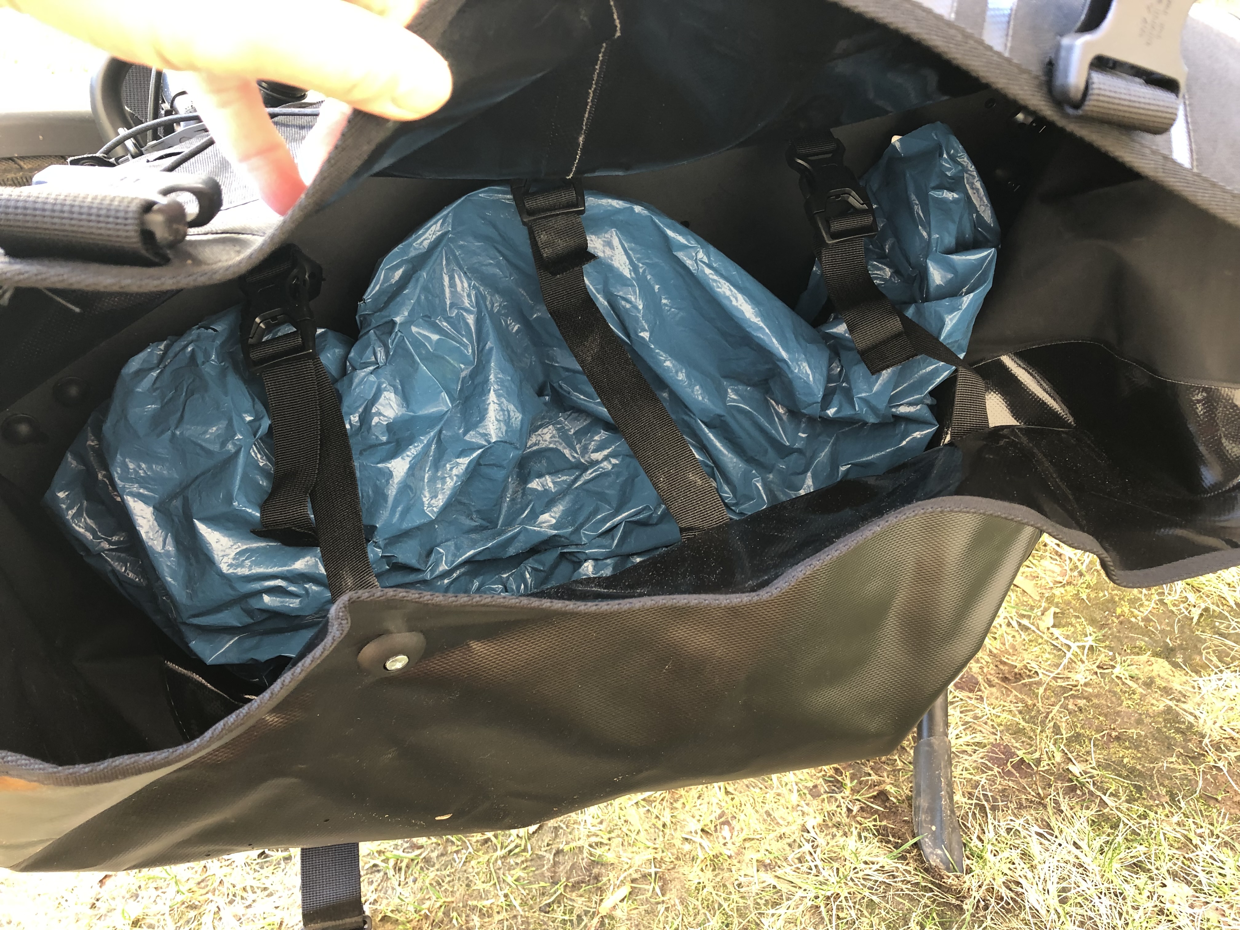 Das ist der Blick in die Tasche. Ich habe die Mülltüte absichtlich drin gelassen, damit man die drei Riemen sieht, mit denen man die Tasche innen zusammenhalten kann. Die Riemen, zumindest zwei davon, waren für den Transport von dem Hinterrad, recht praktisch.