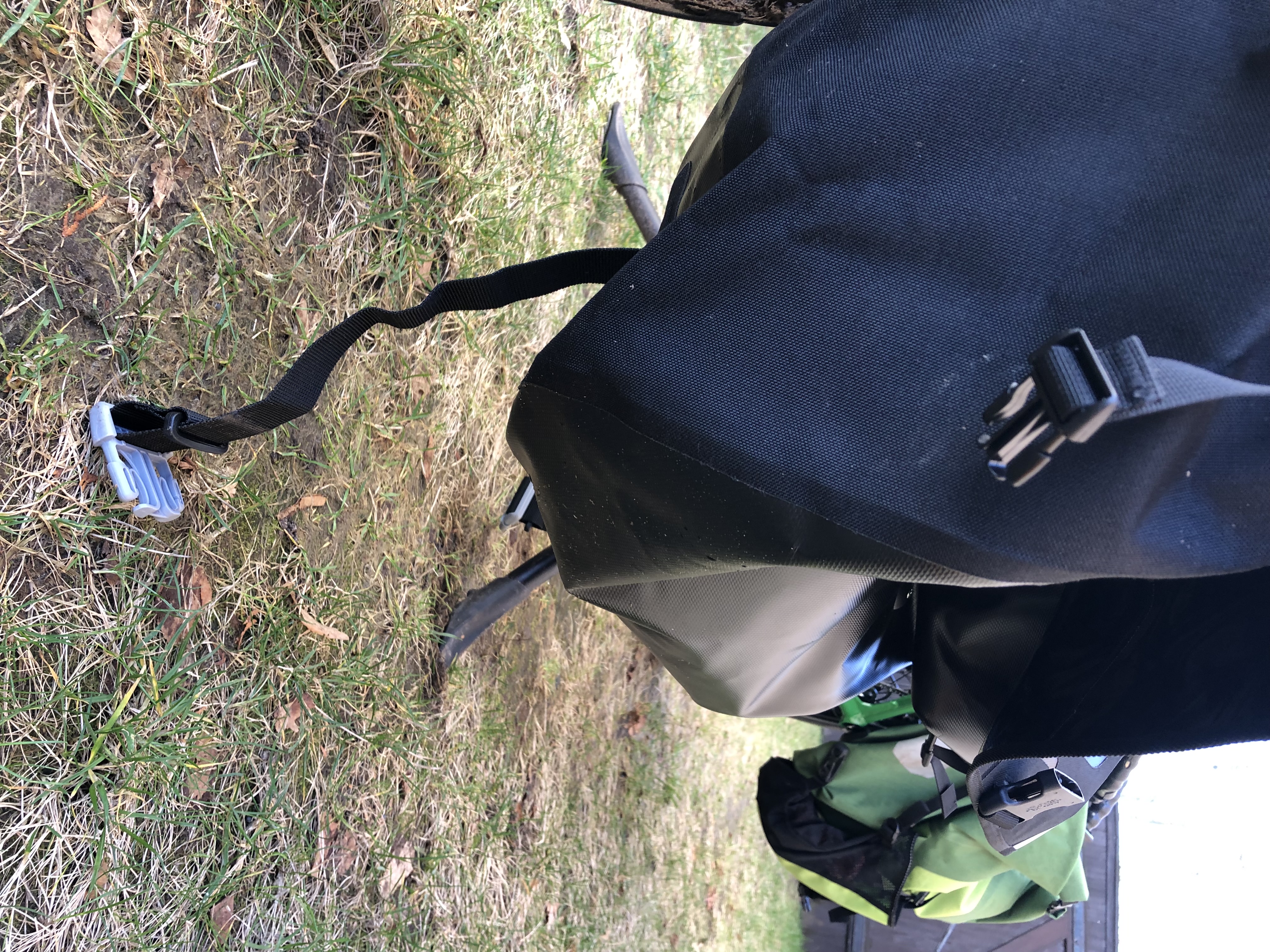 Was ein bisschen unpraktisch ist, ist dass man die Tasche eigentlich immer zumachen muss, weil sonst die Schnallen am Boden schleifen. Oder man muss die Riemen, also die Schnallen an den Riemen, so weit nach oben fummeln, wie geht. Dann schleifen u.U. wenigstens nur die Riemen. Besser wär es für den Einsatz am Pino gewesen, das Ende zum Verstellen wär am Deckel und das Gegenstück unten. Aber es ist halt keine Pino-Tasche sondern eine Liegeradtasche und an einem hohen Gepäckträger gedacht.